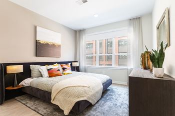 A bedroom with a bed and a large window